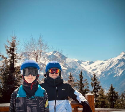 Sidcot students in skiwear posing in front of mountainous scenery