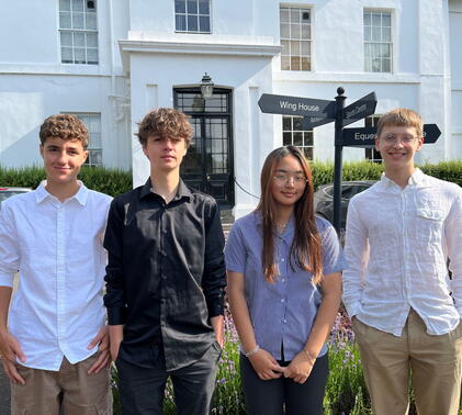 Four work experience students standing outside school.