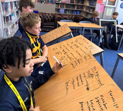 boys writing on their desks