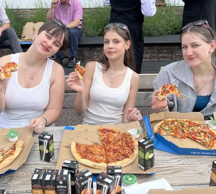 Three students eating pizza