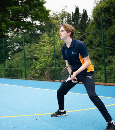 boy in sidcot uniform playing tennis